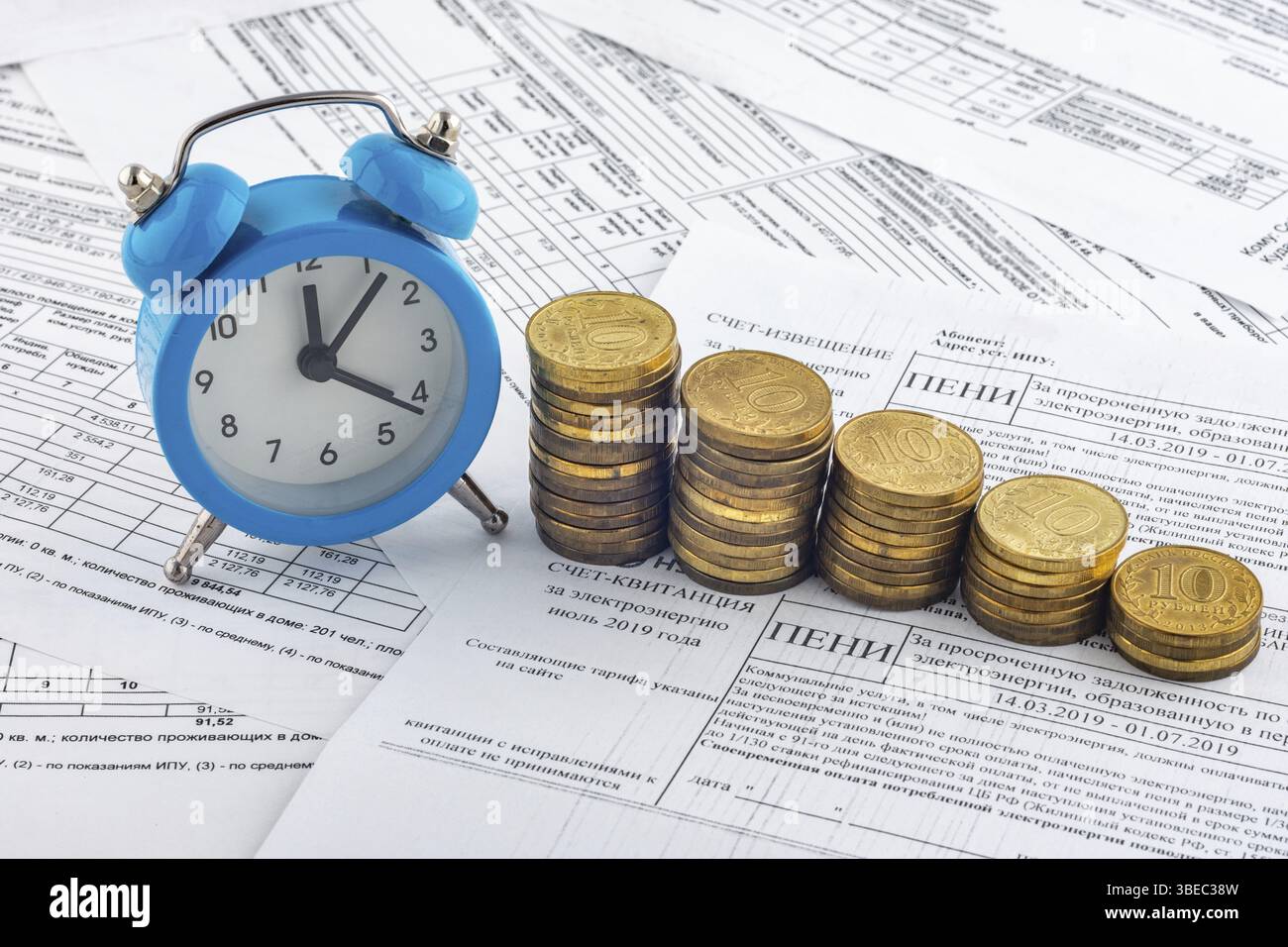 Heures, des piles de pièces de monnaie, reçu avec l'intérêt couru sur le paiement de l'électricité Banque D'Images