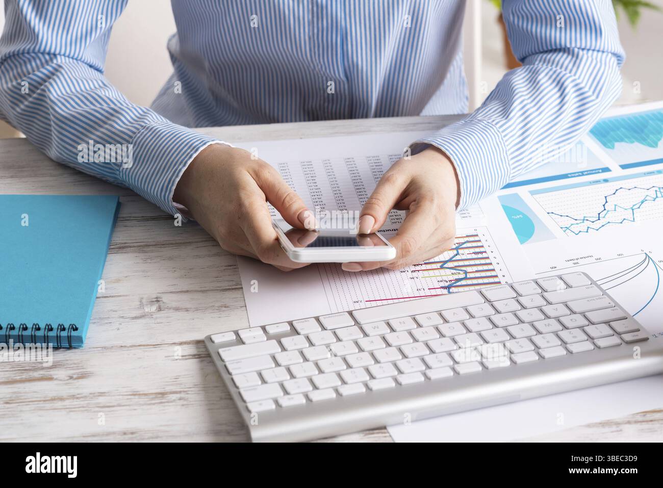 Femme d'affaires assise au bureau et utilisant un smartphone. Bureau d'entreprise avec clavier d'ordinateur. Métier d'entreprise concept avec femme d'affaires Banque D'Images