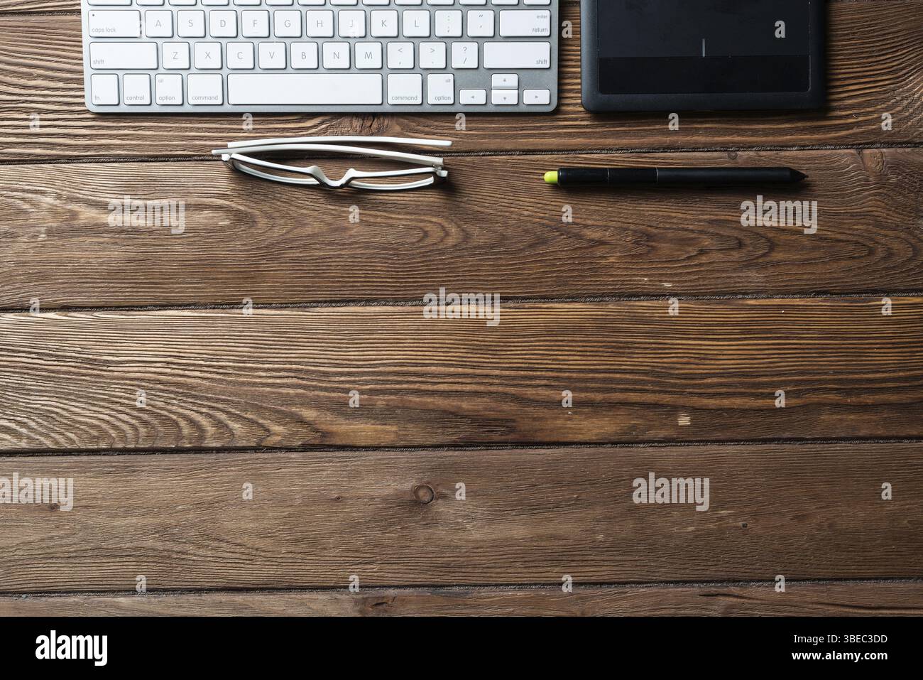Vue de dessus de l'espace de bureau composition. Mise à plat vintage bureau en bois avec un clavier de pc et tablette de dessin graphique. Design et de la créativité. Gestion des temps Banque D'Images