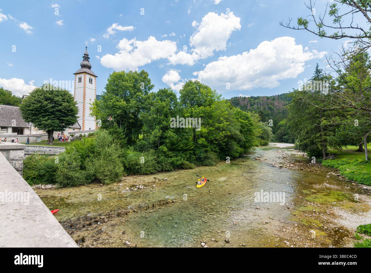 Église de Bohinj, Slovénie - vue sur la rivière dans le village de Ribcev Laz. Touriste sur le kayak et canoë sur la rivière. Randonnée dans les alpes slovènes et Trigla Banque D'Images