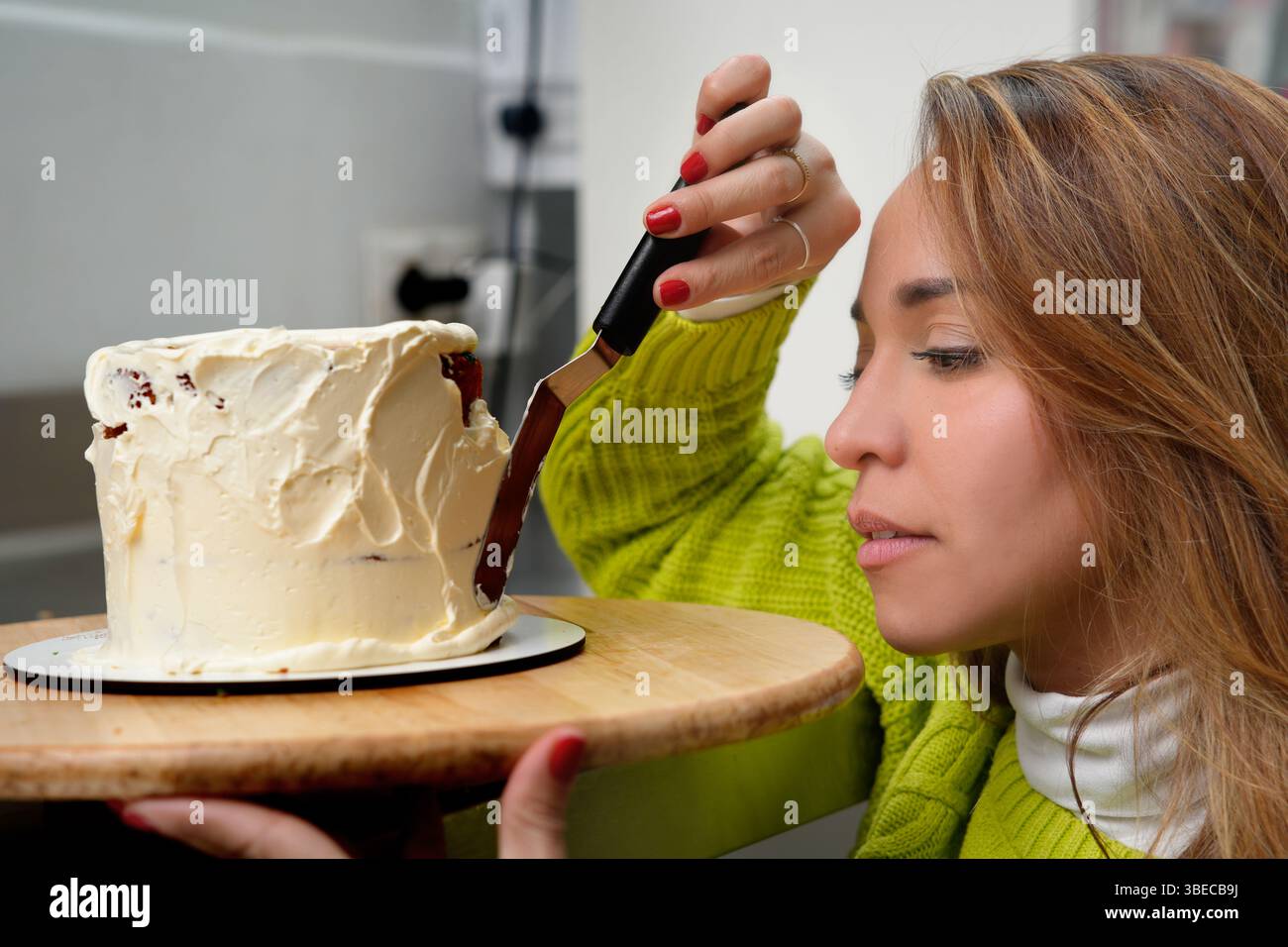 jeune pâtissier hispanique décorant un gâteau Banque D'Images