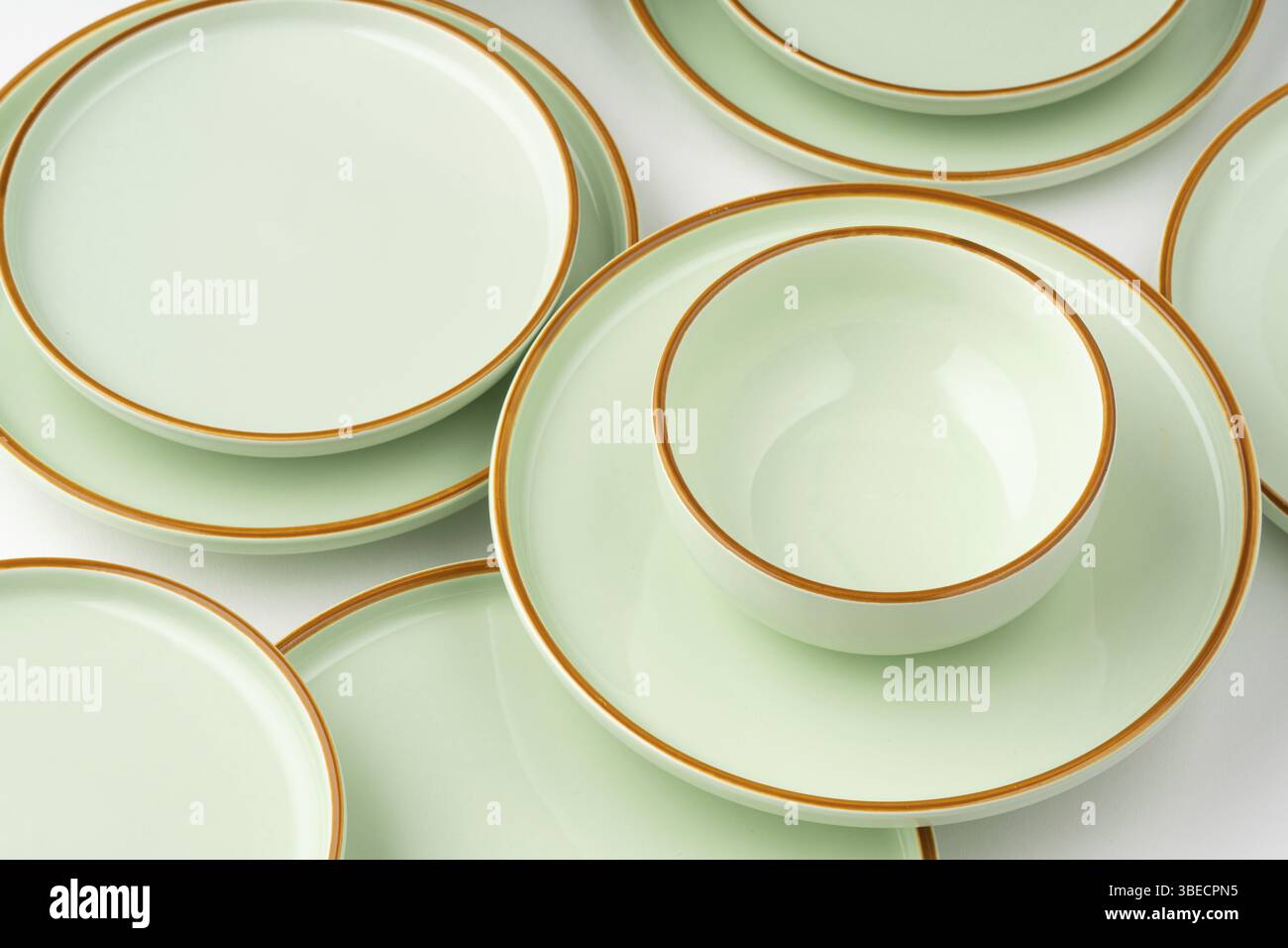 Un ensemble de vaisselle en céramique vert pastel aux contours orange Banque D'Images