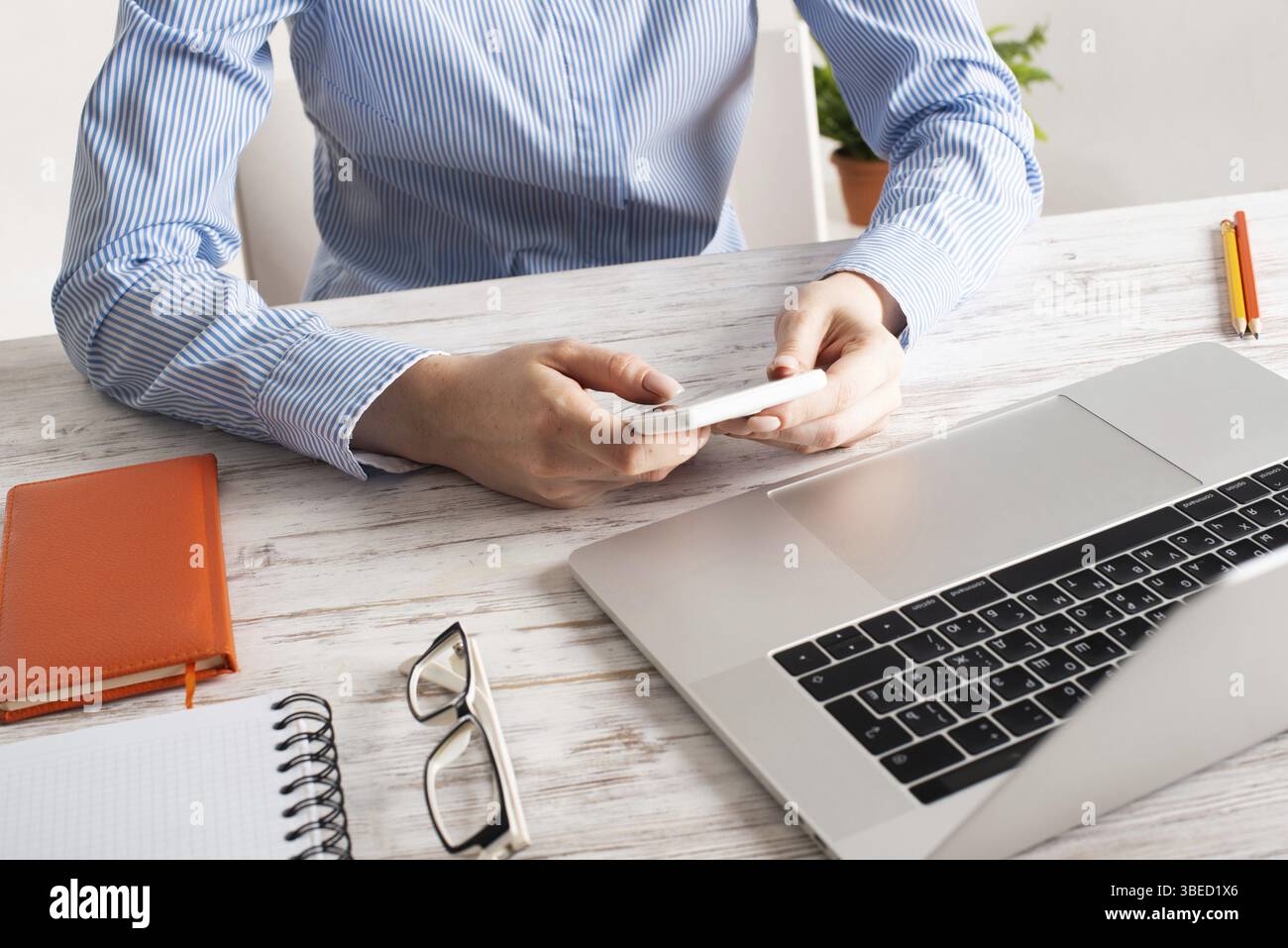 Femme d'affaires assise à un bureau et utilisant un téléphone portable. Bureau d'entreprise avec ordinateur. Concept d'occupation d'entreprise avec femme d'affaires au vin Banque D'Images