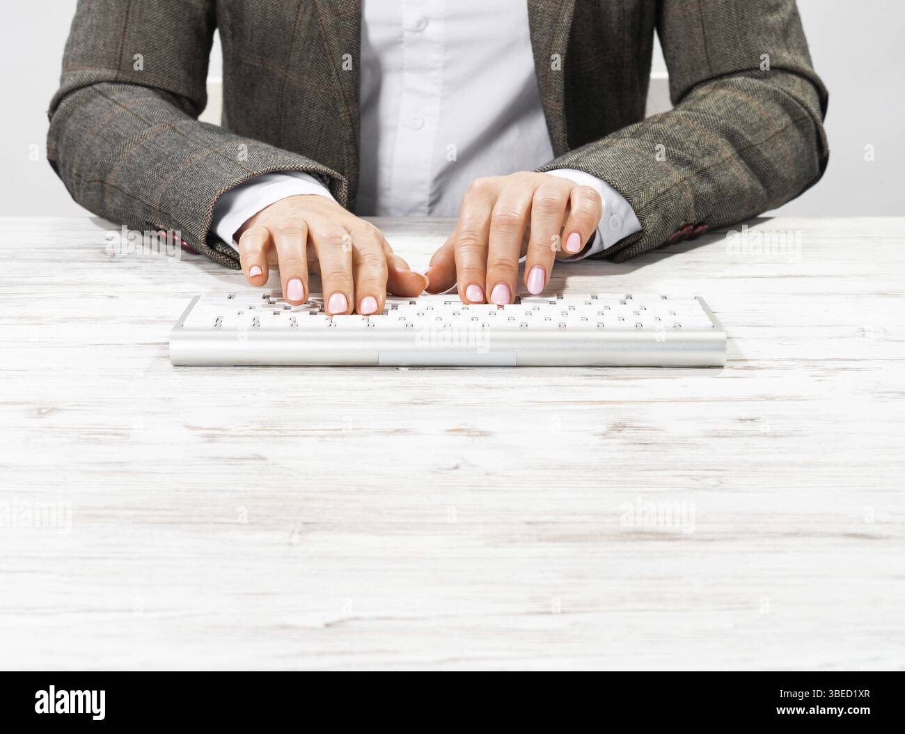 Gros plan des mains de femme tapant sur le clavier de l'ordinateur. Femme d'affaires travaillant au bureau. Femme d'entreprise en costume à son lieu de travail dans le bureau. Manager utilisant DIG Banque D'Images