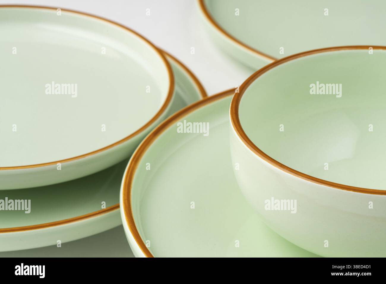 Un ensemble de vaisselle en céramique vert pastel aux contours orange Banque D'Images