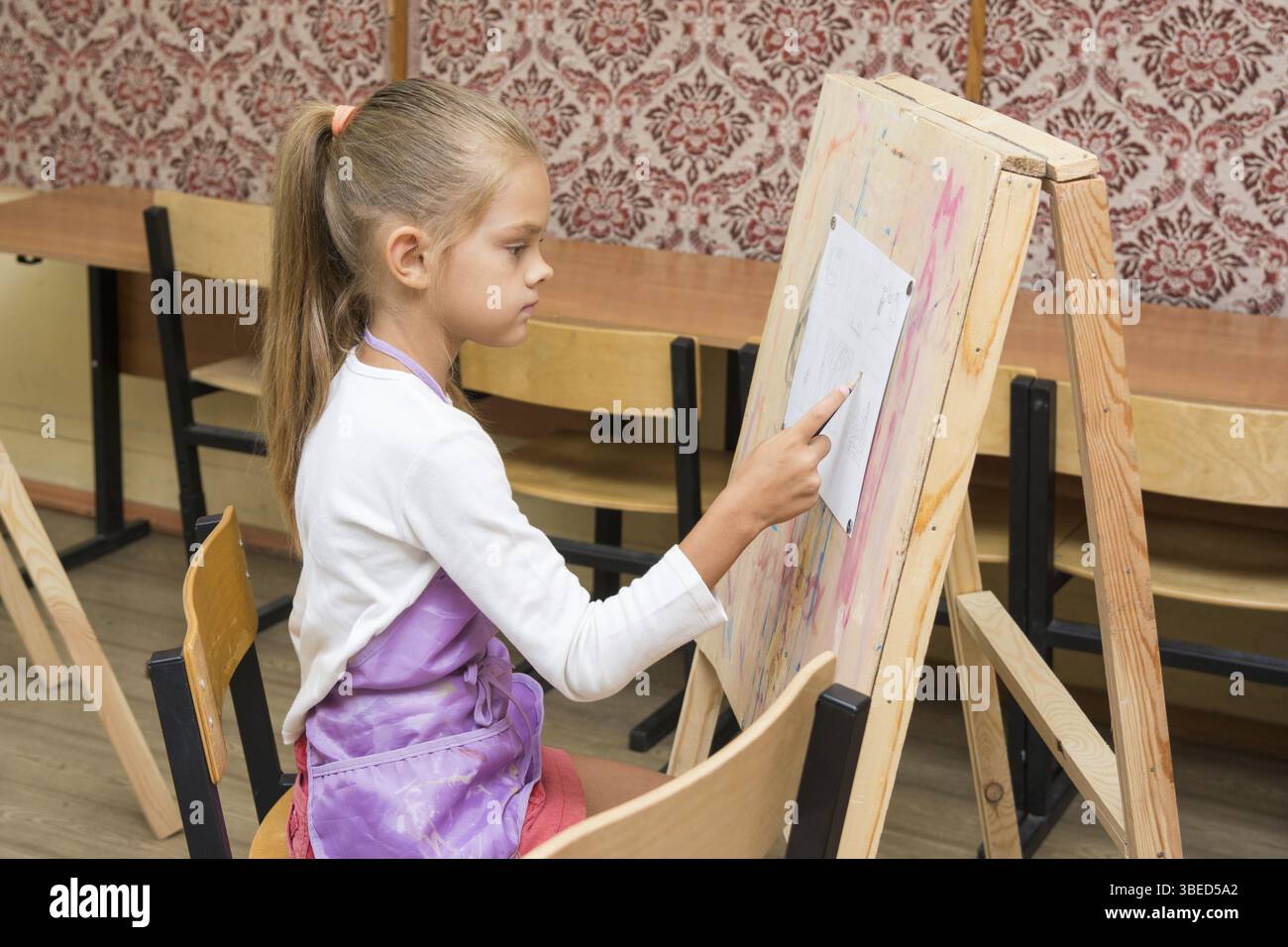 Girl artiste peint sur un chevalet pour dessiner circle Banque D'Images
