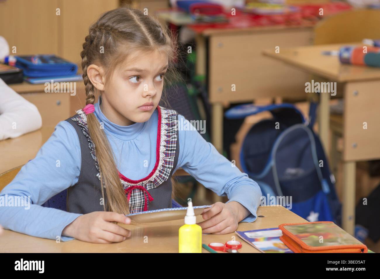 Fille dans l'école pour la classe du travail n'a pas compris la tâche et d'un air perplexe à l'enseignant à Banque D'Images