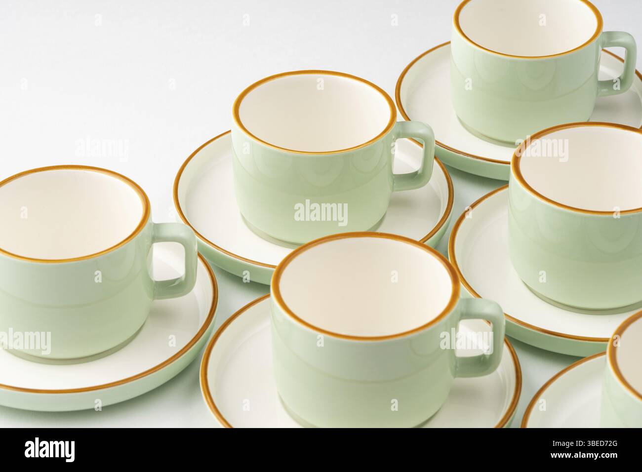 Un ensemble de tasses en céramique blanc et vert pastel aux contours orange Banque D'Images