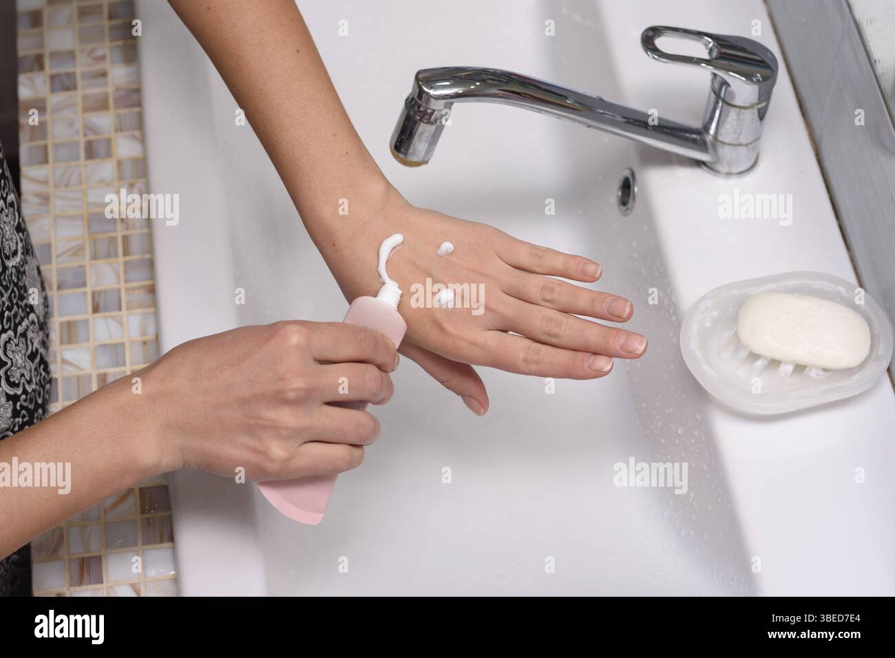 La fille a appliqué la crème à la peau de ses mains sous la forme d'un émoticône Banque D'Images