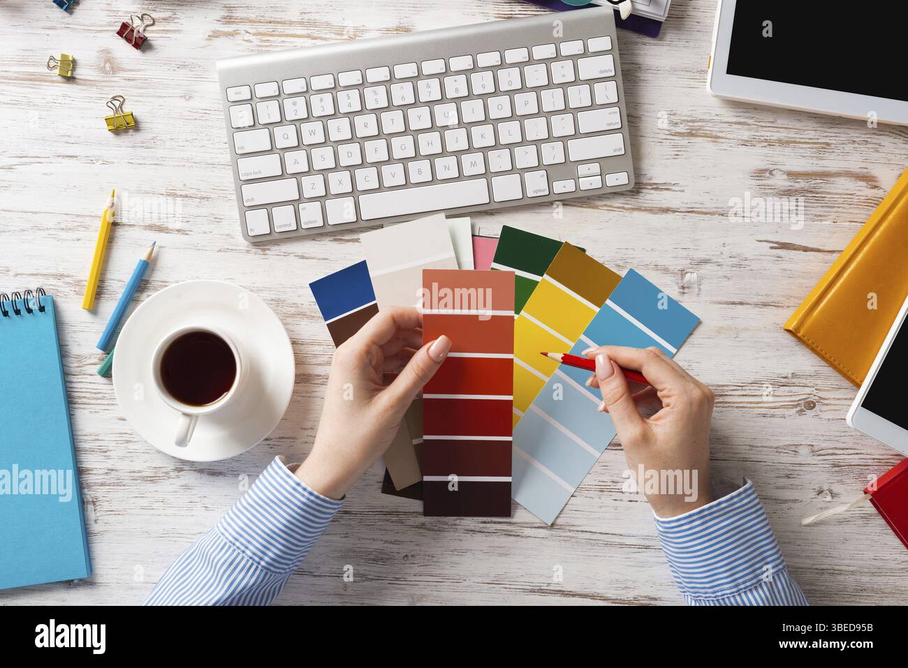 Concepteur Web choisissant des couleurs à partir de nuances au bureau en bois. Lieu de travail de bureau avec clavier d'ordinateur et tasse de café. Conception de l'interface utilisateur de mobi Banque D'Images