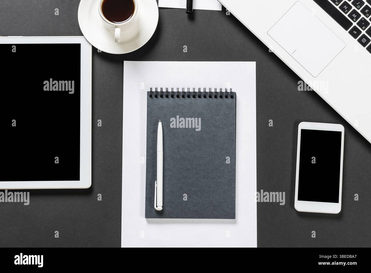 Vue de dessus du lieu de travail design avec des appareils numériques modernes. Design contemporain à plat avec surface noire. Technologie numérique et mode de vie mobile. Banque D'Images