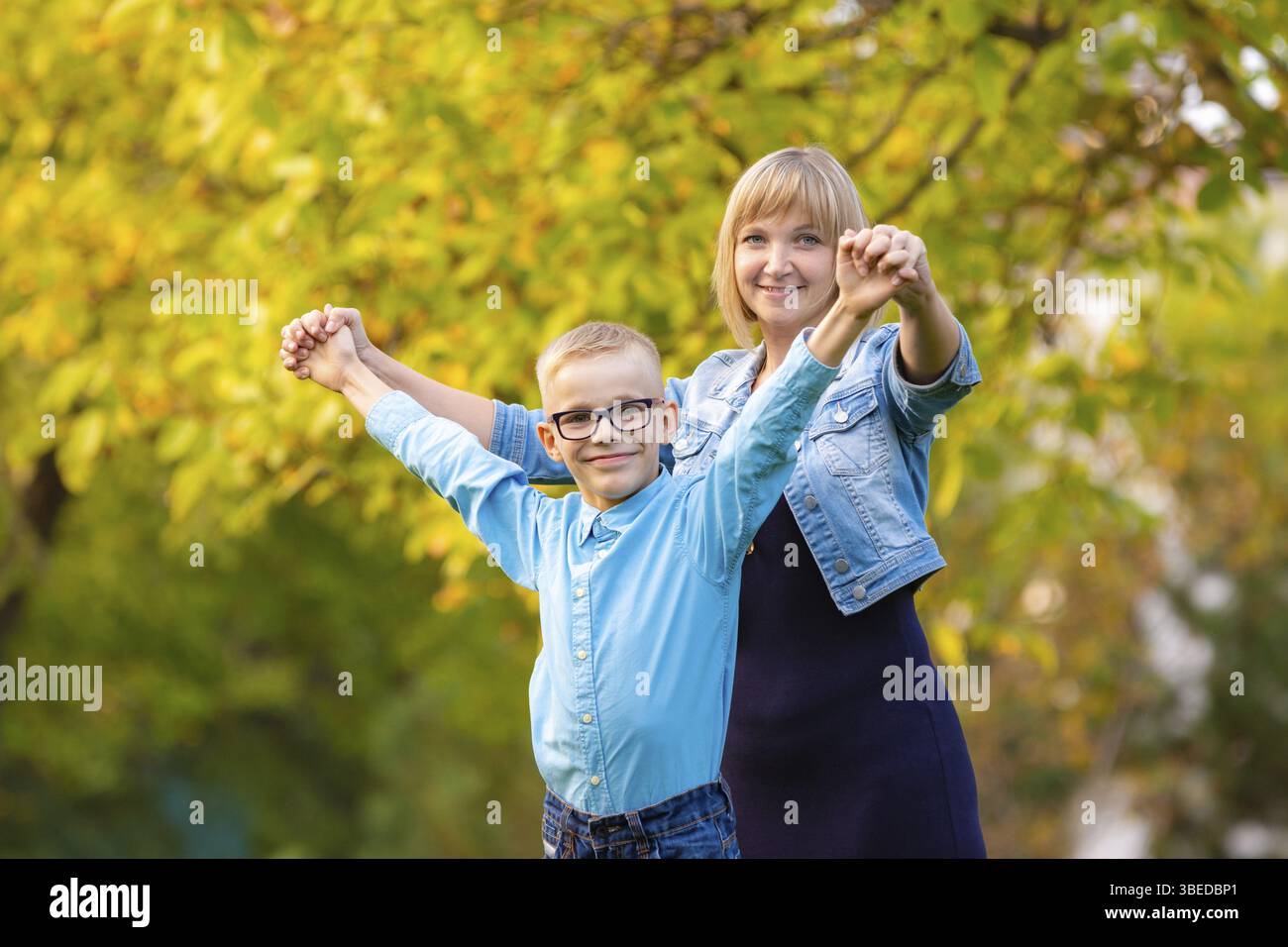 Maman et son fils de sept ans s'amusent dans le parc d'automne Banque D'Images
