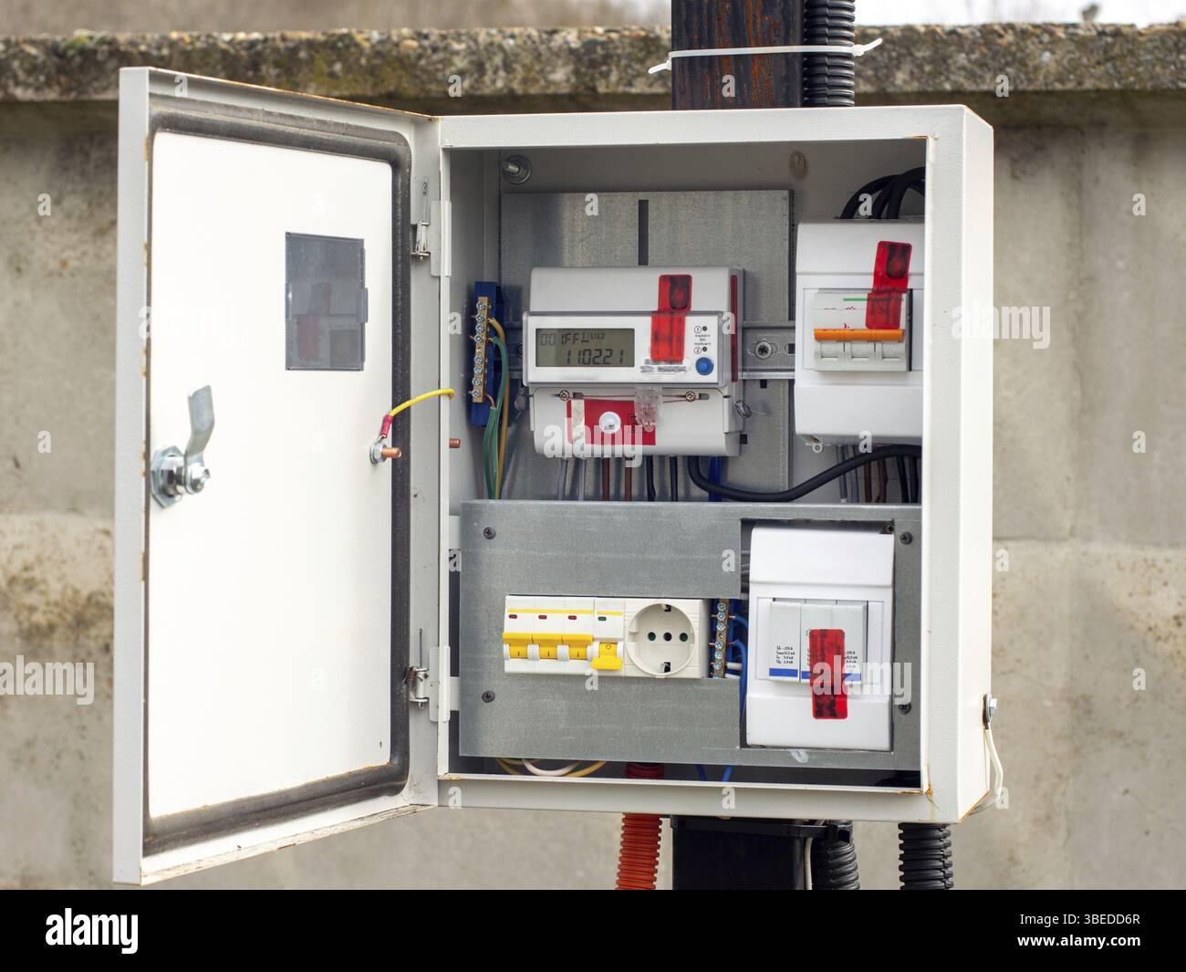 Machine d'introduction et compteur d'énergie électrique dans un tableau de bord sur un pôle sur un terrain Banque D'Images