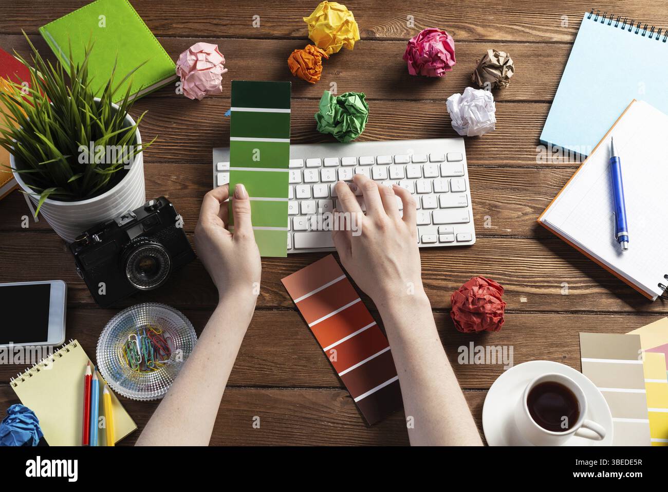 Concepteur Web choisissant des couleurs à partir de nuances au bureau en bois. Bureau vue de dessus avec clavier d'ordinateur et papeterie. Conception de l'interface utilisateur o Banque D'Images