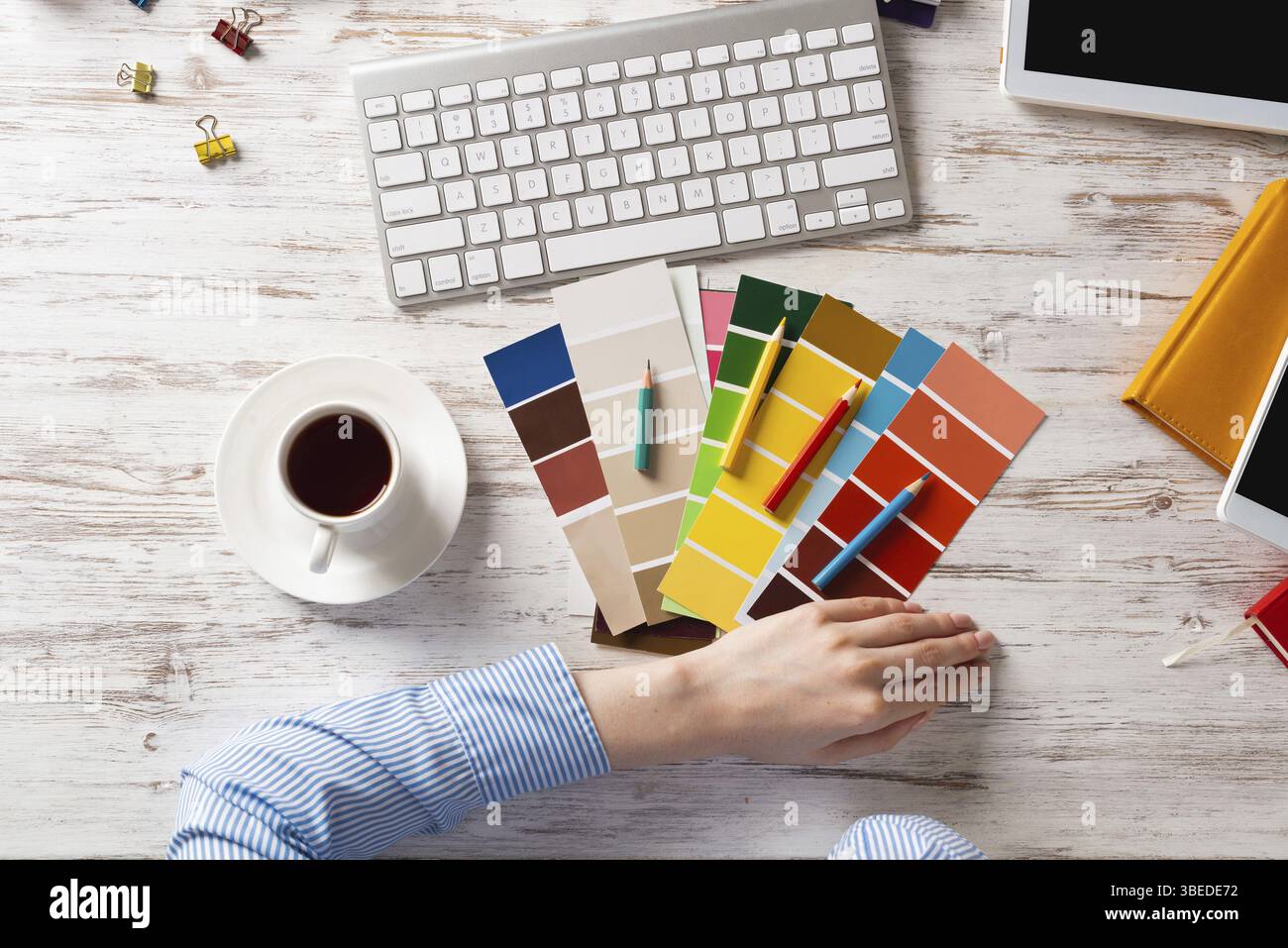 Concepteur Web choisissant des couleurs à partir de nuances au bureau en bois. Lieu de travail de bureau avec clavier d'ordinateur et tasse de café. Conception de l'interface utilisateur de mobi Banque D'Images