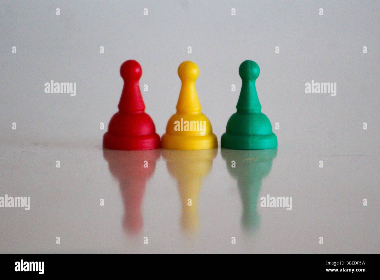 Trois pions de jeu en rouge, jaune et vert représentant les couleurs nationales de la Bolivie, du Burkina Faso, du Ghana, de la Guinée et de la Guinée-Bissau. Minim symbolique Banque D'Images