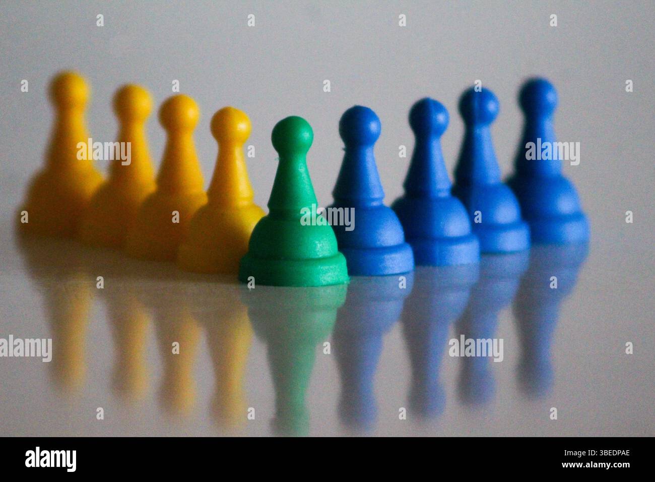 Concept créatif montrant comment le jaune et le bleu se combinent pour créer du vert, symbolisé par des pions de jeu colorés. Idéal pour la conception, le travail d'équipe et l'éducation de couleur Banque D'Images