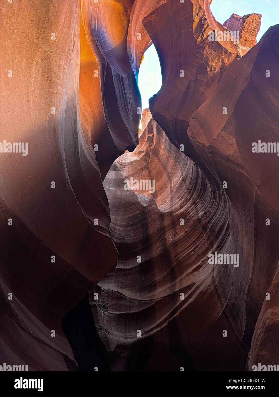 La lumière du soleil illumine les murs de grès sculptés d'Antelope Canyon, un canyon à fente de renommée mondiale situé dans la nation Navajo près de page, en Arizona. - Image de stock capturée avec un smartphone