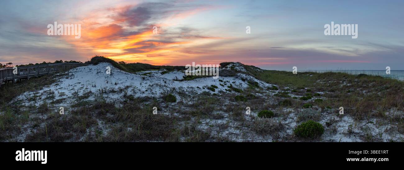 La promenade pittoresque du parc d'État Top Sail Hill à destin Florida traverse les dunes de sable blanc immaculé pendant un lever de soleil coloré. Banque D'Images