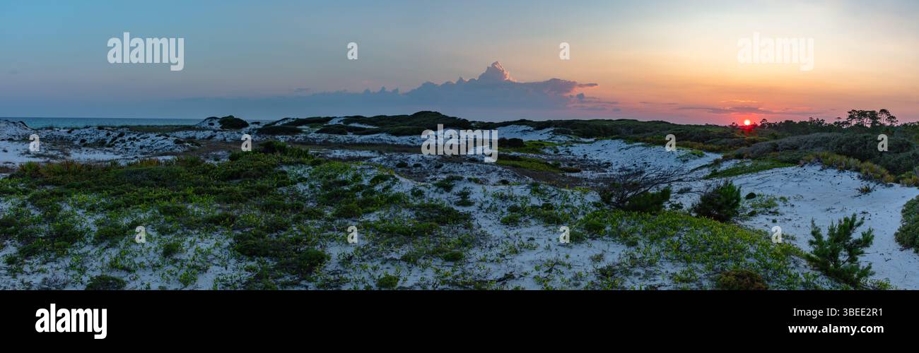 Un beau coucher de soleil sur les dunes de sable blanc du parc d'État Top Sail Hill à destin Floride. Banque D'Images