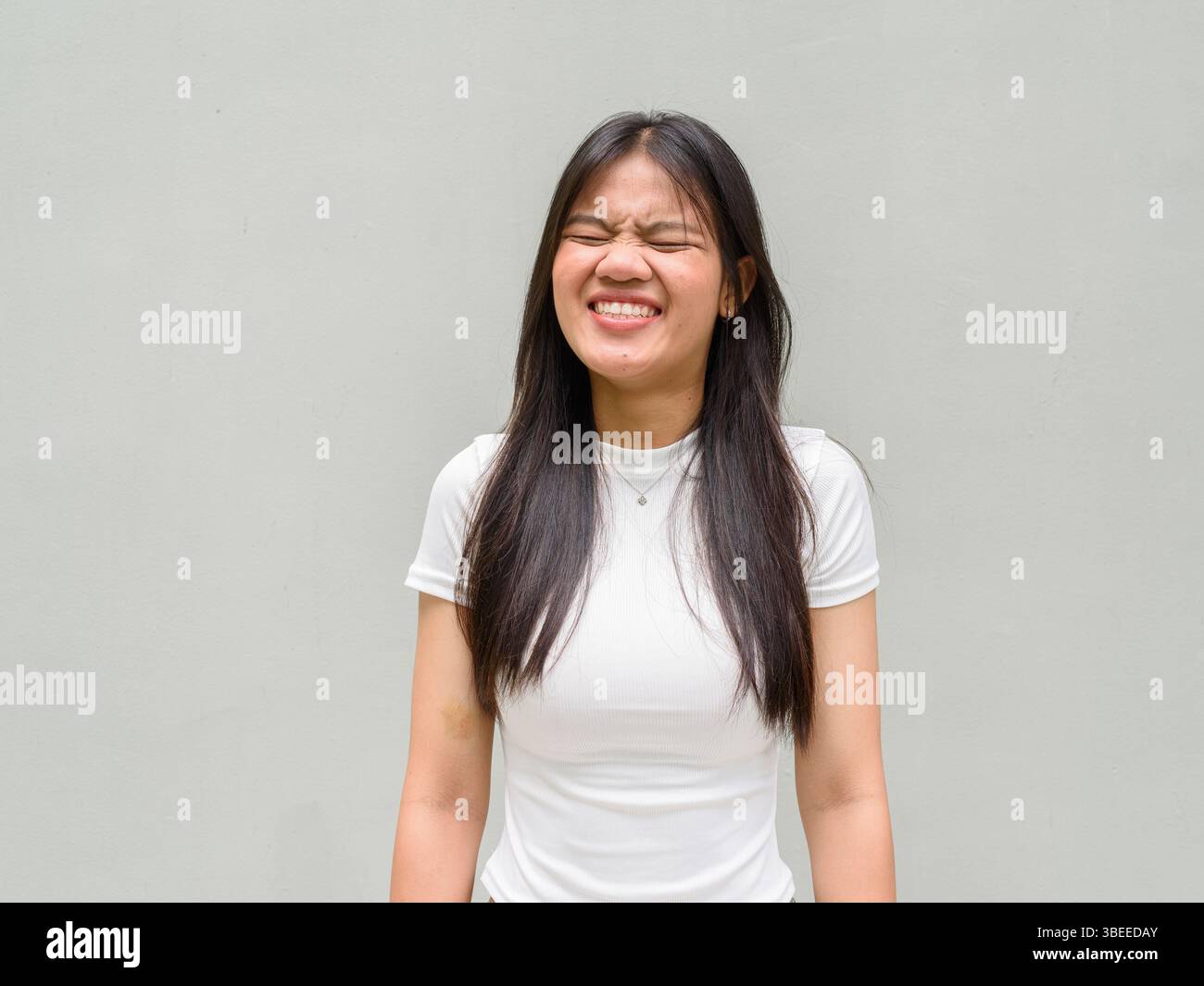 Portrait de belle jeune femme asiatique sur fond de mur simple Banque D'Images