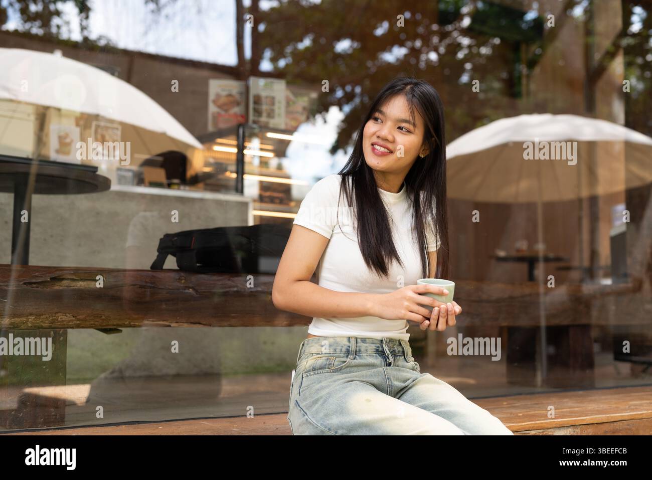 Jeune belle femme asiatique se relaxant à l'extérieur du café dans la ville Banque D'Images