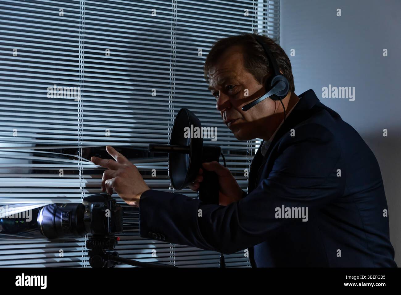 Scène de surveillance avec équipement professionnel : caméra, ordinateur portable, microphone directionnel Banque D'Images