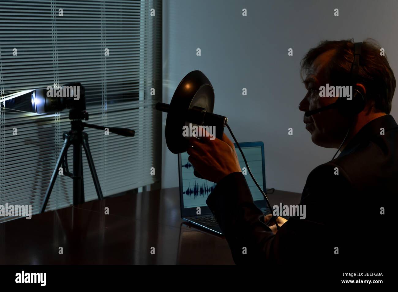 Le détective effectue une surveillance secrète en utilisant des gadgets modernes et des enregistrements sonores Banque D'Images