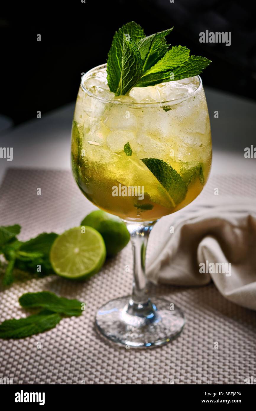 Cocktail mojito avec glace, menthe et garniture de citron vert sur table moderne, gros plan Banque D'Images