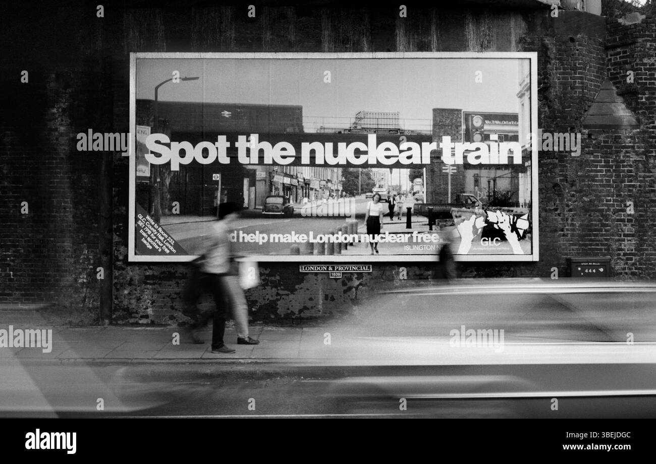 Une affiche du GLC « Aidez Londres à libérer du nucléaire » sous un pont de chemin de fer dans une rue de Londres. L'affiche, l'une des quatre photographies de Martin Bond de trains nucléaires à Londres, a été produite par le GLC en 1983 pour coïncider avec l'enquête publique Sizewell 'B'. La photo montre une fiole nucléaire sur la North London Line traversant Caledonian Road, Londres N1. Banque D'Images