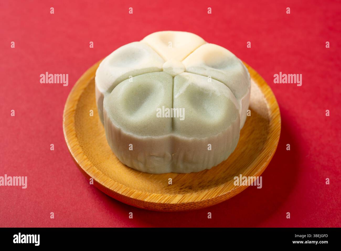 vue d'angle forme de fleur blanc et vert clair mooncake sur rouge Banque D'Images