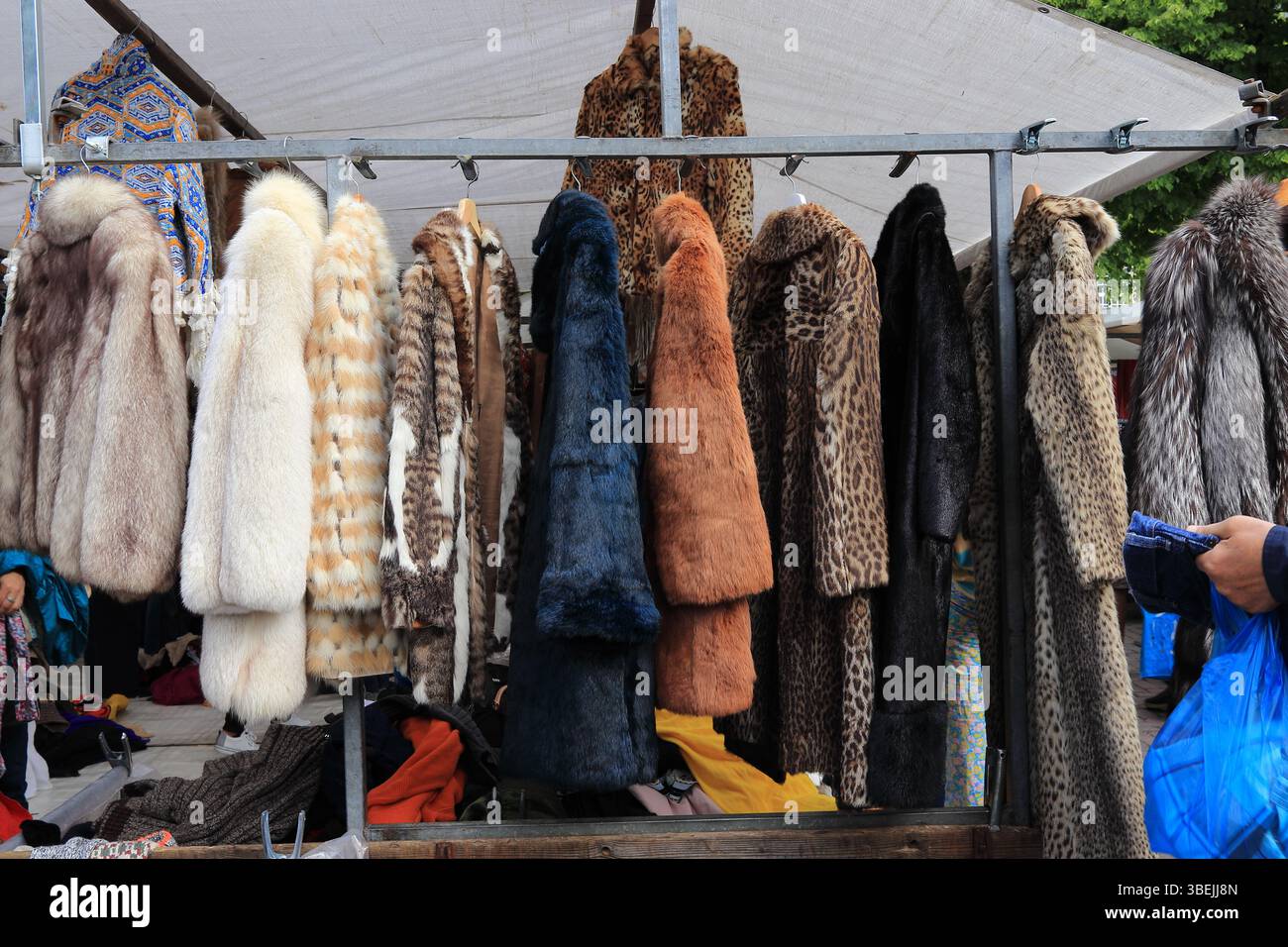 Divers manteaux de fourrure accrochés sur un support à un étal de marché Noordermarkt à Amsterdam, pays-Bas, 2025. Banque D'Images