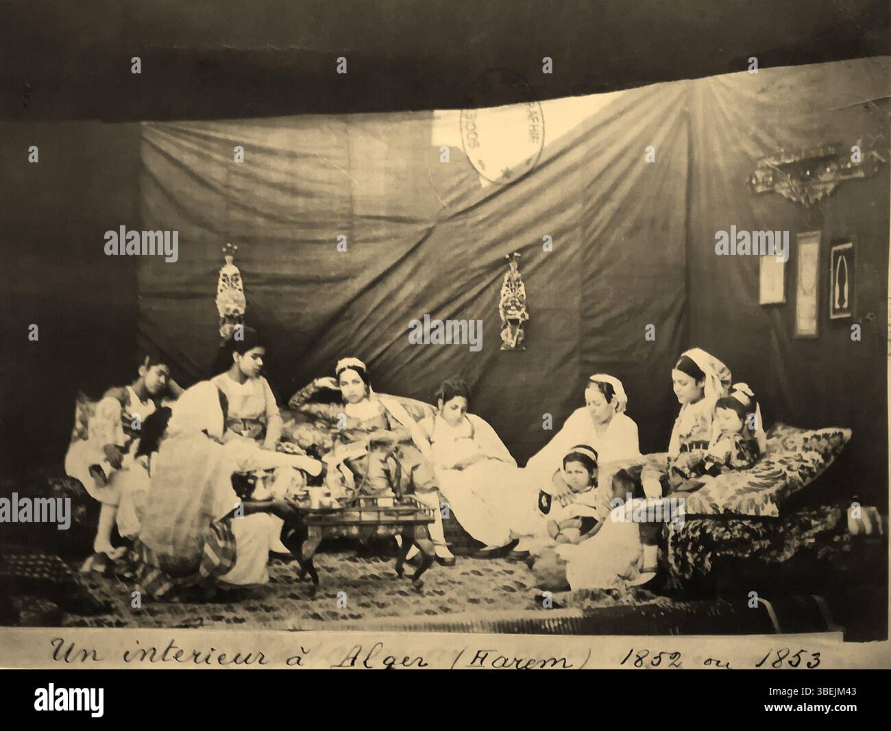 Cette œuvre d'art non datée, dont on pense qu'elle date de 1852 ou 1853, représente une scène intérieure à Alger, mettant en valeur un harem. La pièce donne un aperçu de l'art orientaliste du XIXe siècle et de la représentation des espaces nord-africains par des artistes européens. Banque D'Images