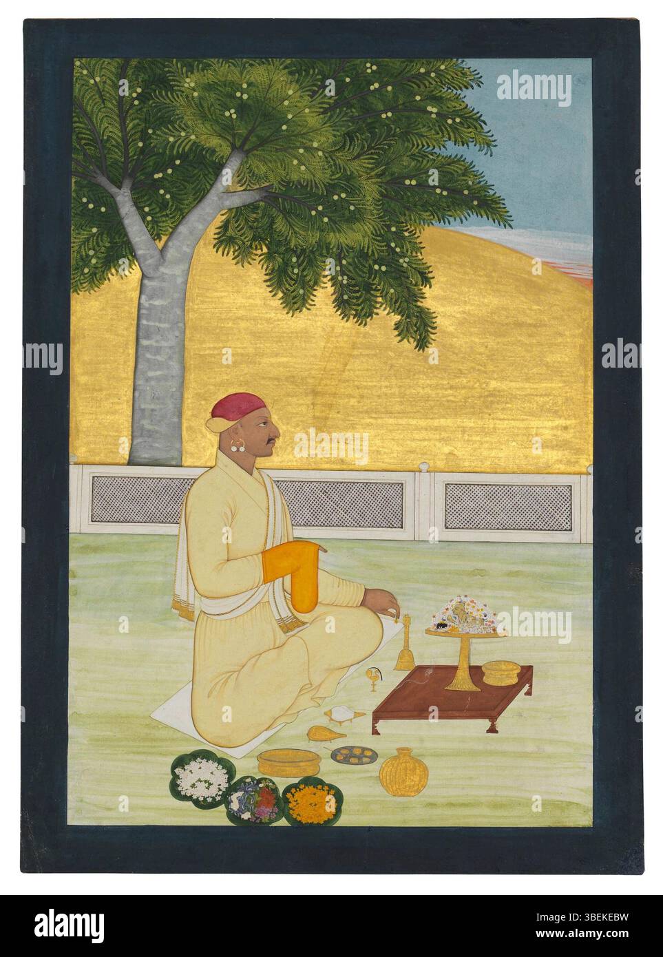 Ce tableau, attribué à Pandit Seu, représente Raja Dalip Singh de Guler State jouant puja, vers 1740. La peinture utilise des pigments opaques et de l'or sur papier, avec une bordure bleu foncé. Banque D'Images