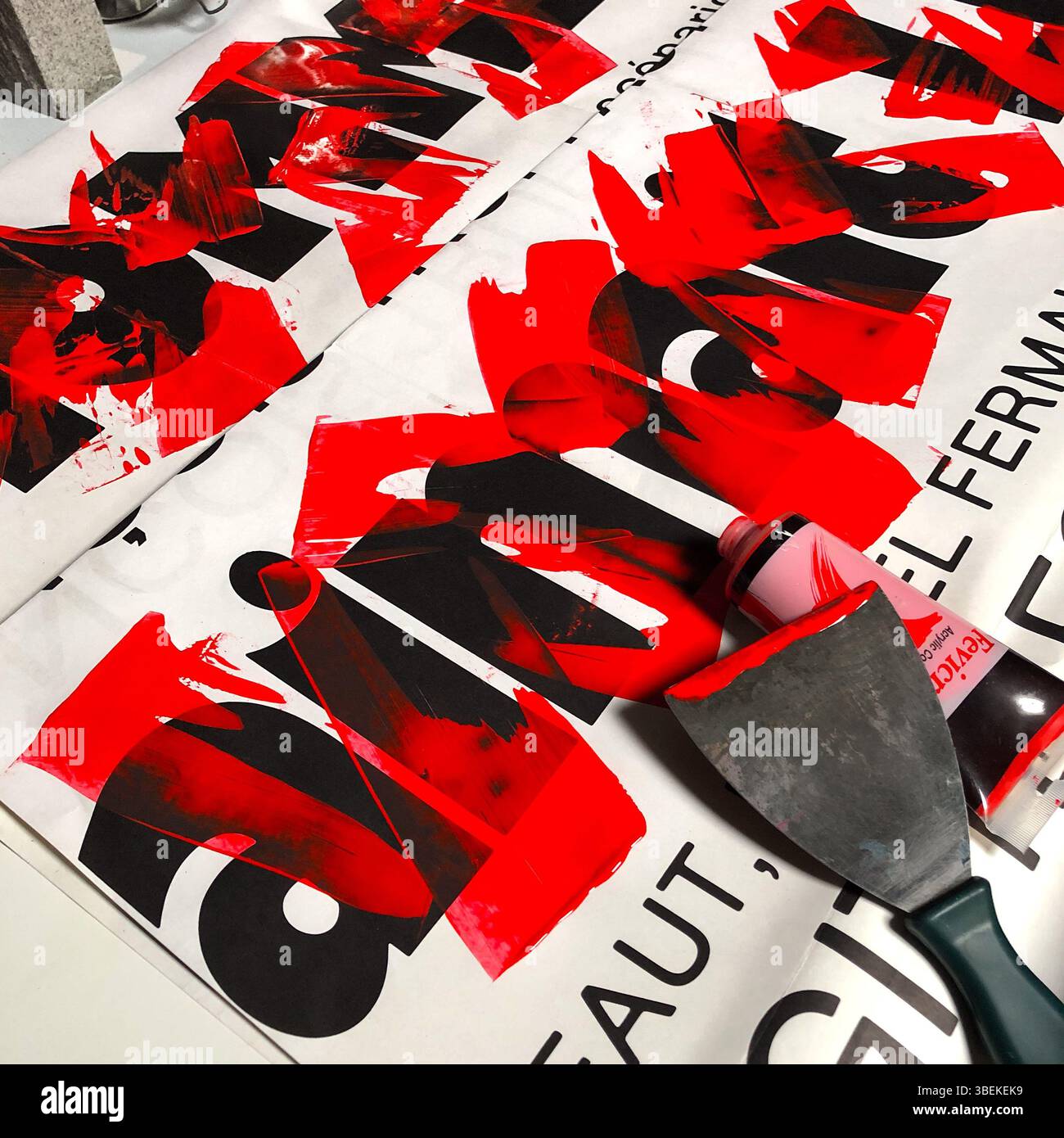 Illustration par Ed Buziak sur le plan de travail de studio en utilisant la typographie de vieilles affiches de film recouvertes de peinture acrylique rouge - France. Banque D'Images