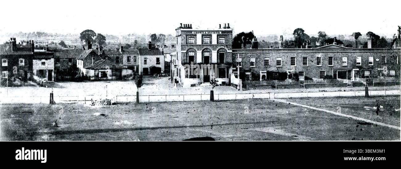 Cette première photographie de 1863 capture le côté nord de Turnham Green, Londres, avec le pub Crown and Anchor, offrant un aperçu de la vie de rue et de l'architecture de l'époque victorienne. Banque D'Images