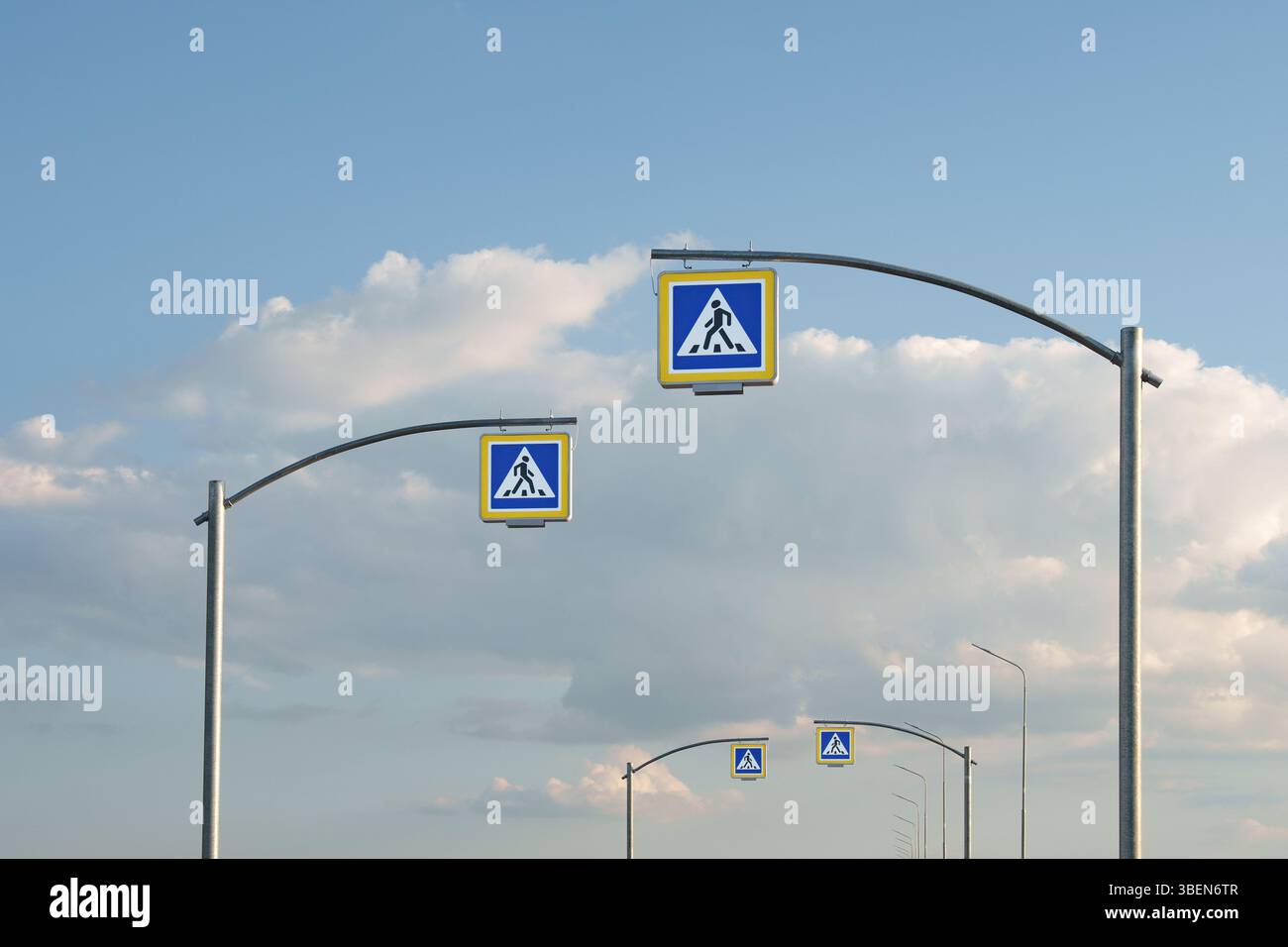 Route moderne avec panneaux de passage piétonnier sous Blue Sky. Planification urbaine, gestion du trafic, sécurité routière, conception des infrastructures et des transports. Banque D'Images