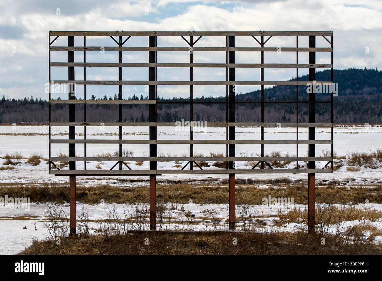 Un grand panneau d'affichage en hiver, avec la publicité complètement soufflée. Seul le cadre reste. Banque D'Images