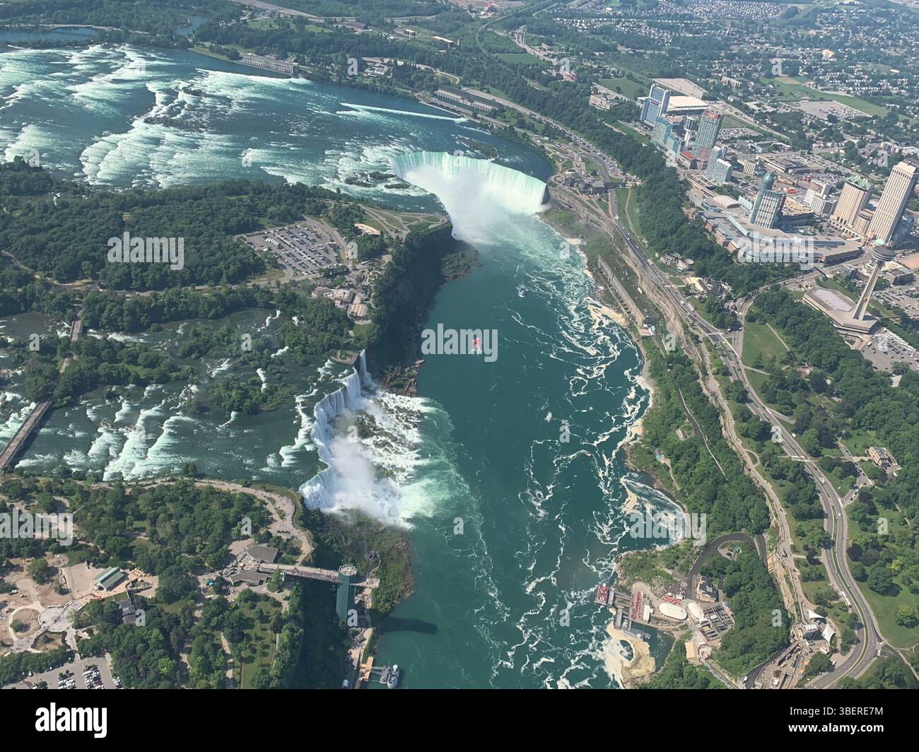 Vue aérienne des chutes du Niagara avec Horseshoe Falls, American Falls et les villes des côtés américain et canadien par une journée d'été ensoleillée. Banque D'Images