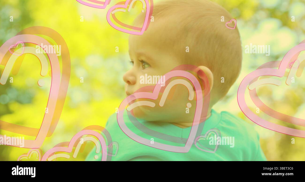 Image de cœurs tombant au-dessus du bébé heureux caucasien Banque D'Images