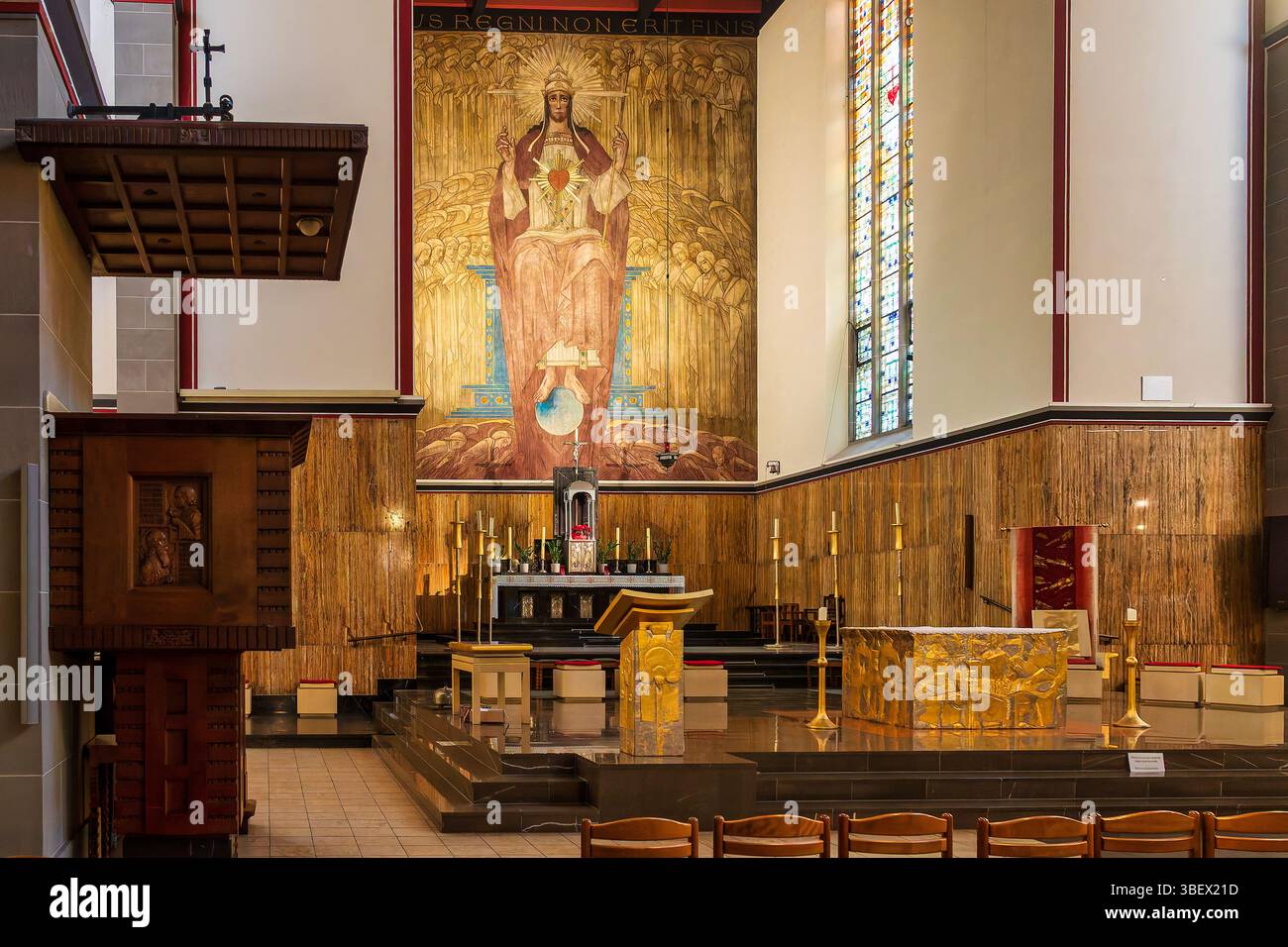 Le maître-autel et la chaire en bois sculpté de l'Église du Sacré-Cœur à Luxembourg, Luxembourg, avec peinture murale du Christ Roi. Banque D'Images