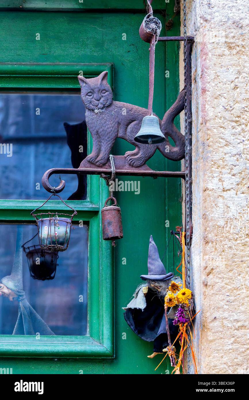 Décoration folklorique de porte de sorcière et chat sur une porte verte au Luxembourg, évoquant les traditions locales. Banque D'Images