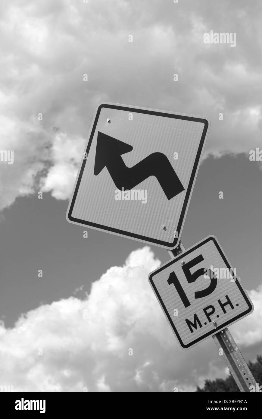 Limite de vitesse et panneau d'avertissement de virage sur une autoroute rurale aux États-Unis, symbolisant le contrôle de la circulation et la sécurité routière. Banque D'Images