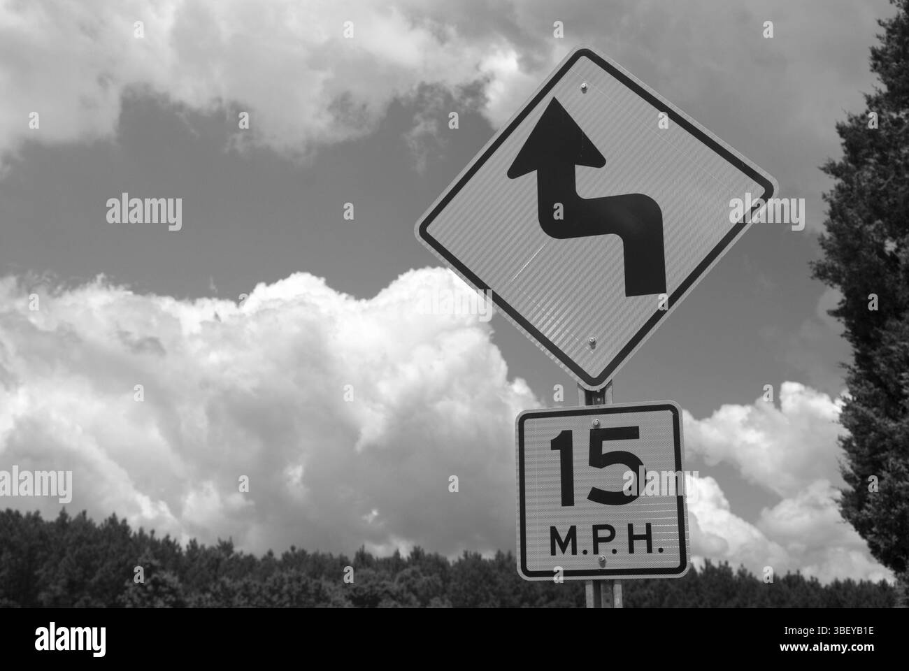 Limite de vitesse et panneau d'avertissement de virage sur une autoroute rurale aux États-Unis, symbolisant le contrôle de la circulation et la sécurité routière. Banque D'Images