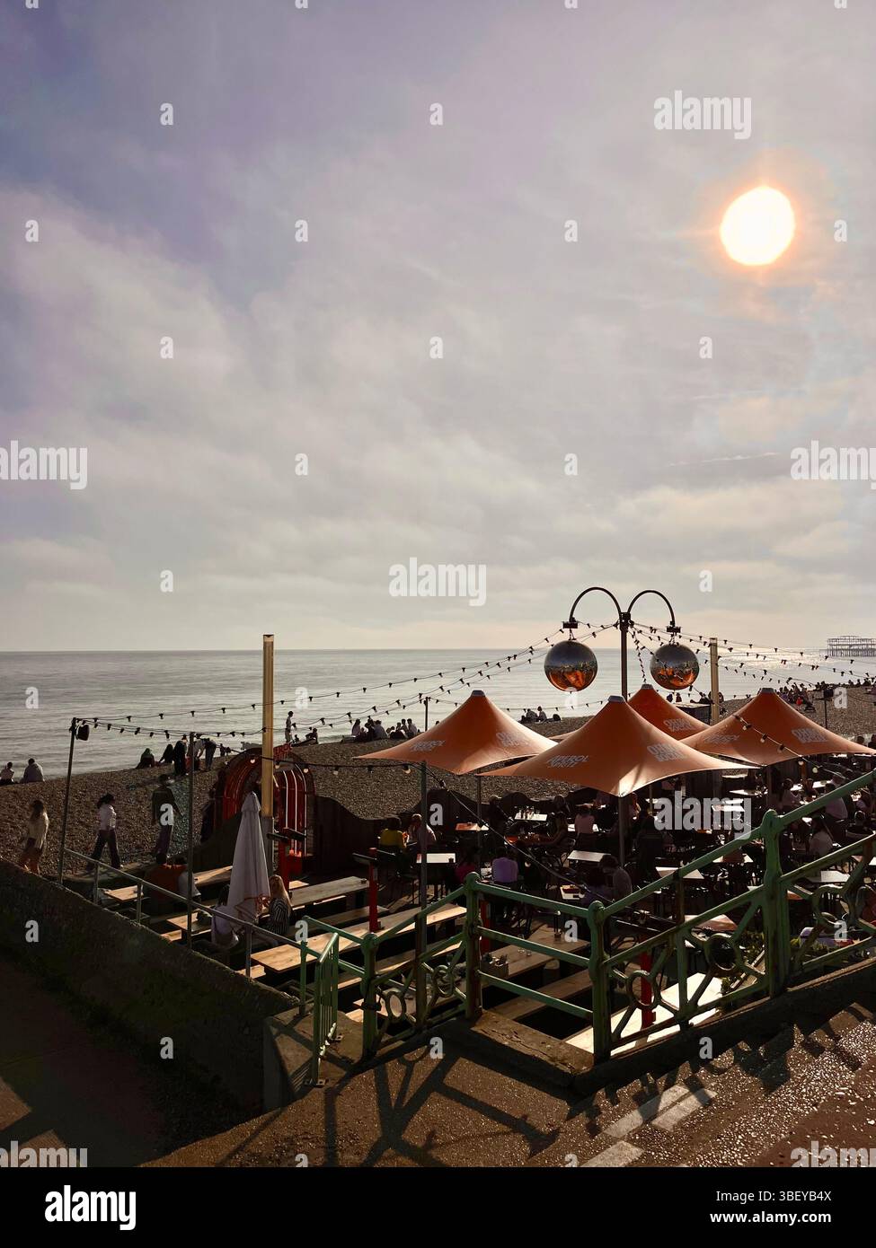 Un bar sur Brighton Beach, Angleterre, Royaume-Uni, Europe pendant l'heure dorée du coucher du soleil au printemps. - Image de stock capturée avec un smartphone