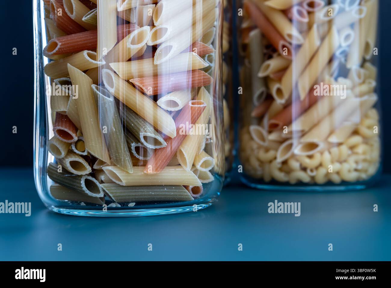 Pâtes Penne colorées dans des pots en verre Banque D'Images