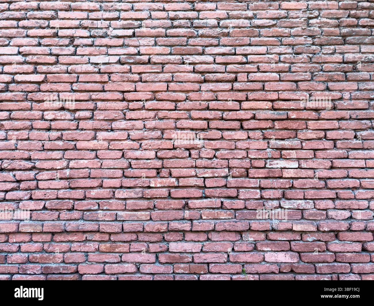 Vieux mur de briques rouges avec texture rugueuse et motif inégal, gros plan, lumière du jour, fond de construction abstrait pour la conception, l'architecture ou la restauration Banque D'Images