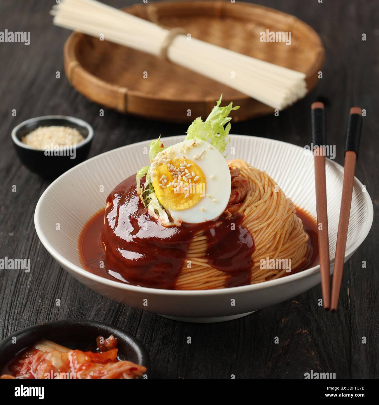 Gros plan sur la cuisine sud-coréenne, les nouilles épicées ou le Bibim Guksu avec une sauce rouge garnie d'œufs bouillis Banque D'Images