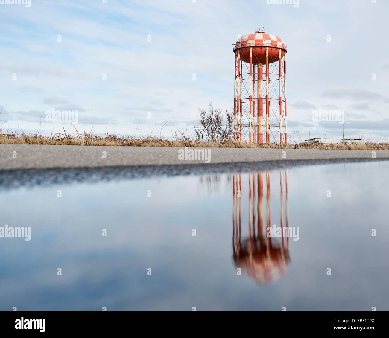 Château d'eau reflétant dans une flaque au bord de la route Banque D'Images