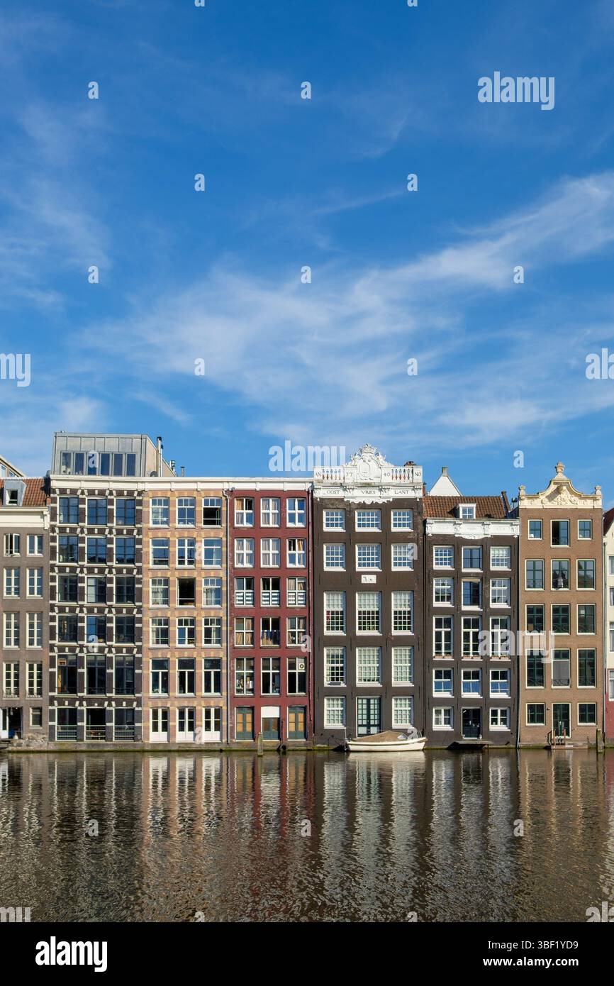 Les maisons de canal d'Amsterdam se reflètent dans l'eau par une journée ensoleillée. L'architecture est historique et colorée. Banque D'Images